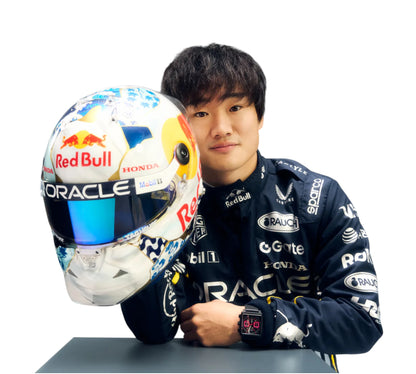 Person in racing suit holding a helmet with visible branding on a white background