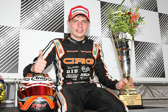 Racing driver holding a trophy and helmet with checkered background