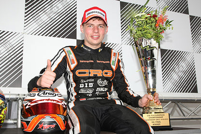 Racing driver holding a trophy and helmet with checkered background
